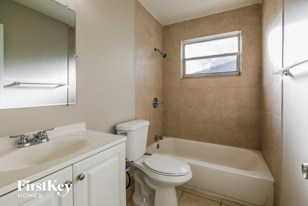 a bathroom with a toilet and a tub and a sink