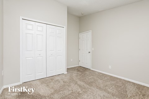 a bedroom with two closets and a carpeted floor