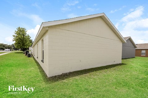 the side of a small white building with a green lawn