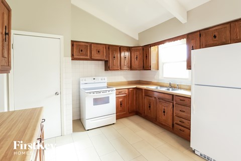 A kitchen with wooden cabinets and white appliances.