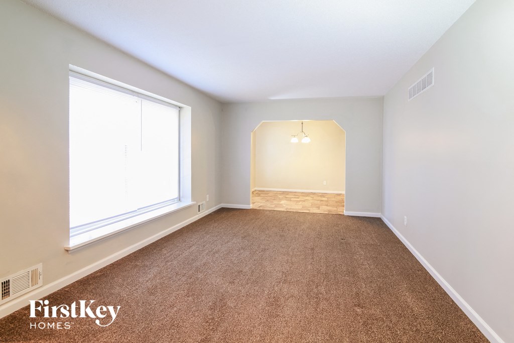 a bedroom with a carpeted floor and a large window