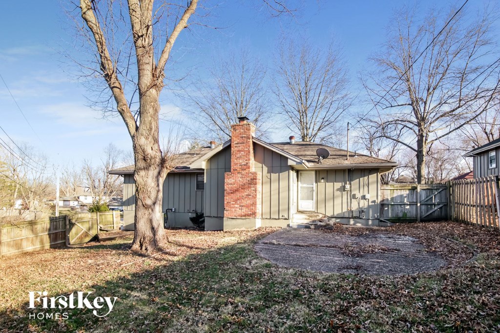 the front of a house with a yard and a tree
