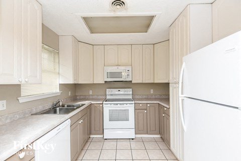 a kitchen with white appliances and white cabinets