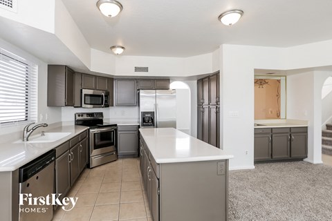 a large kitchen with stainless steel appliances and white counter tops