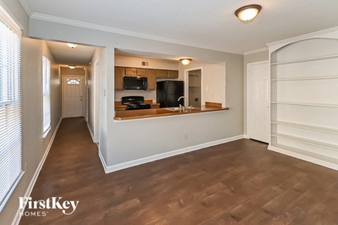 the living room and kitchen of an apartment with wood flooring