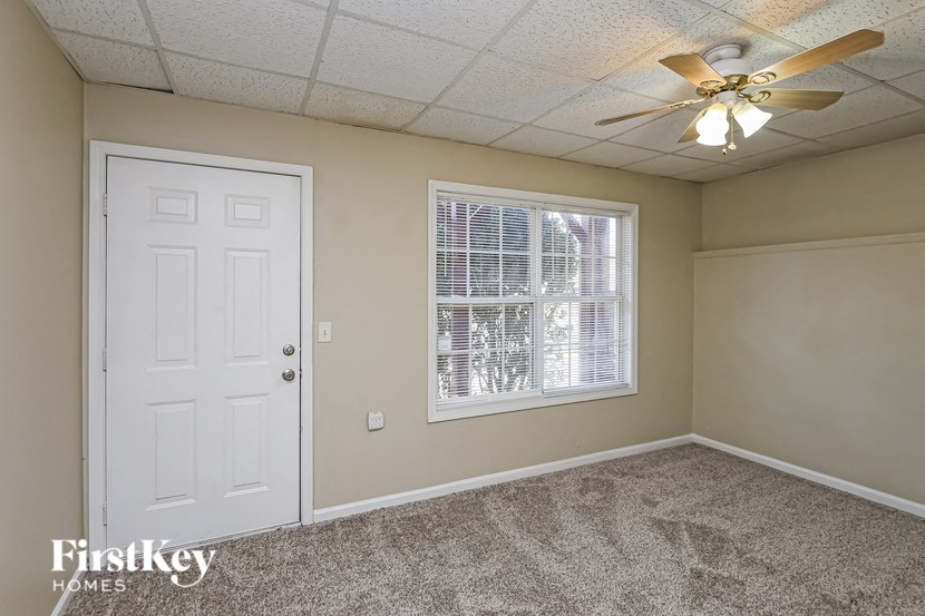 a bedroom with a ceiling fan and a white door