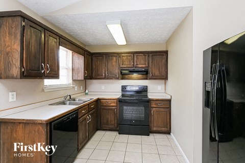 a kitchen with wooden cabinets and black appliances and a sink