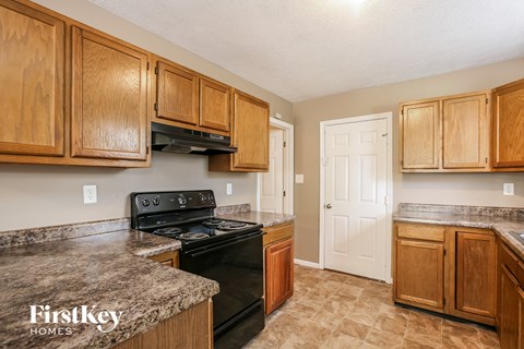 A kitchen with wooden cabinets and a black stove top oven.
