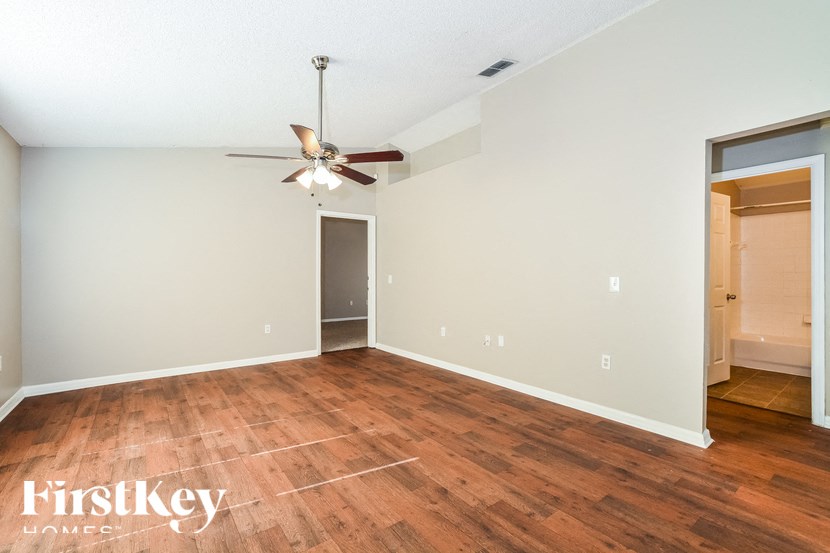 a living room with wood floors and a ceiling fan