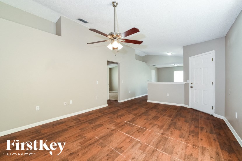 a living room with wood floors and a ceiling fan