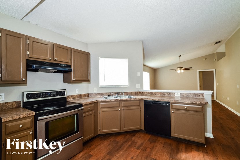 a kitchen with wooden floors and stainless steel appliances