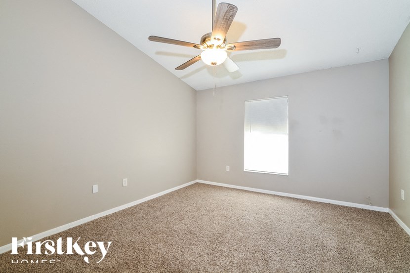 a bedroom with carpet and a ceiling fan
