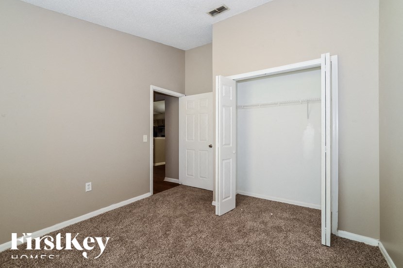 a bedroom with a carpeted floor and a closet with a white door
