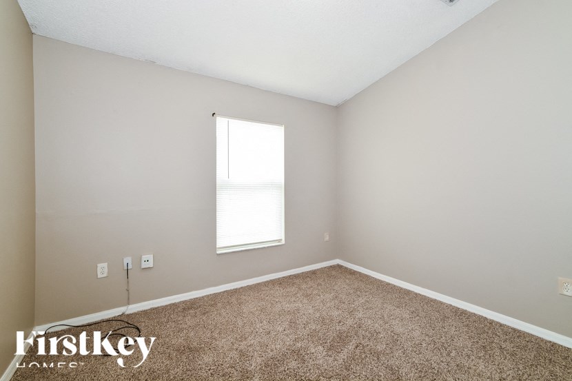 a bedroom with carpet and a window