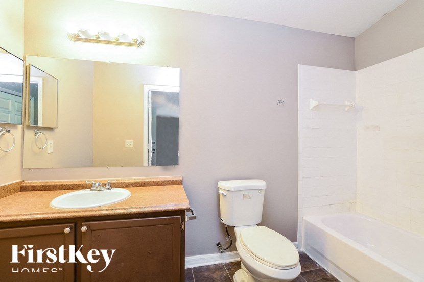 a bathroom with a sink toilet and a mirror