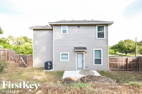 the exterior of a tiny house in a backyard with a wooden fence