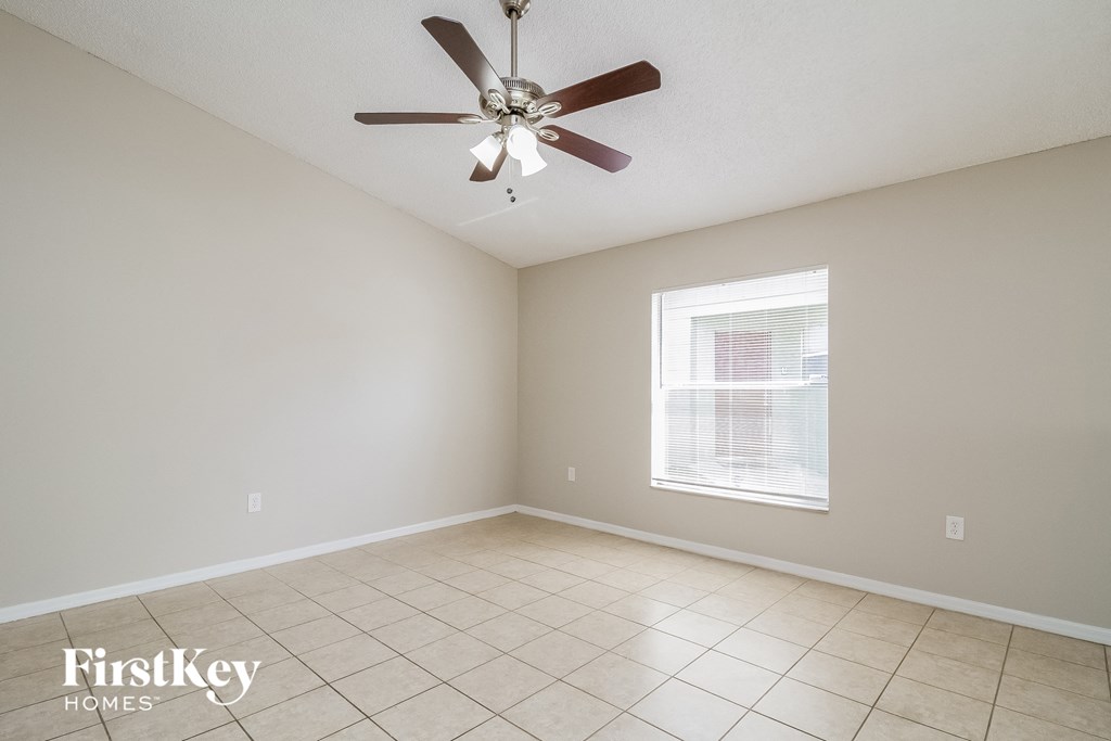 A room with a ceiling fan and a window.
