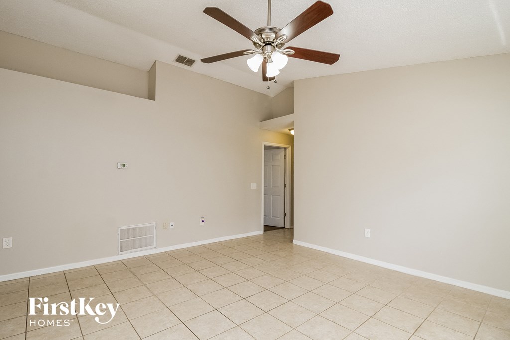 A spacious room with a ceiling fan and tiled floor.