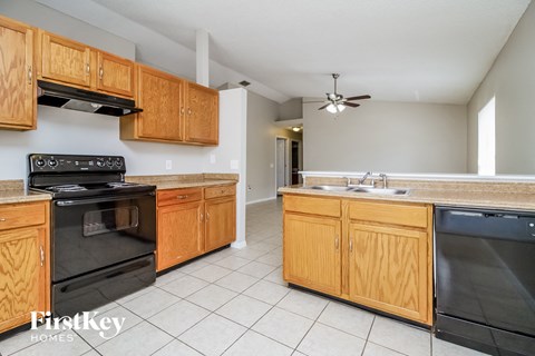 A kitchen with wooden cabinets and black appliances.