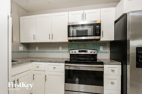A kitchen with a stove top oven and a microwave above it.