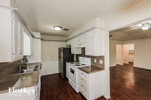 A kitchen with white cabinets and a stainless steel sink.