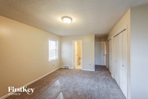 a spacious living room with a carpeted floor and a door to a closet