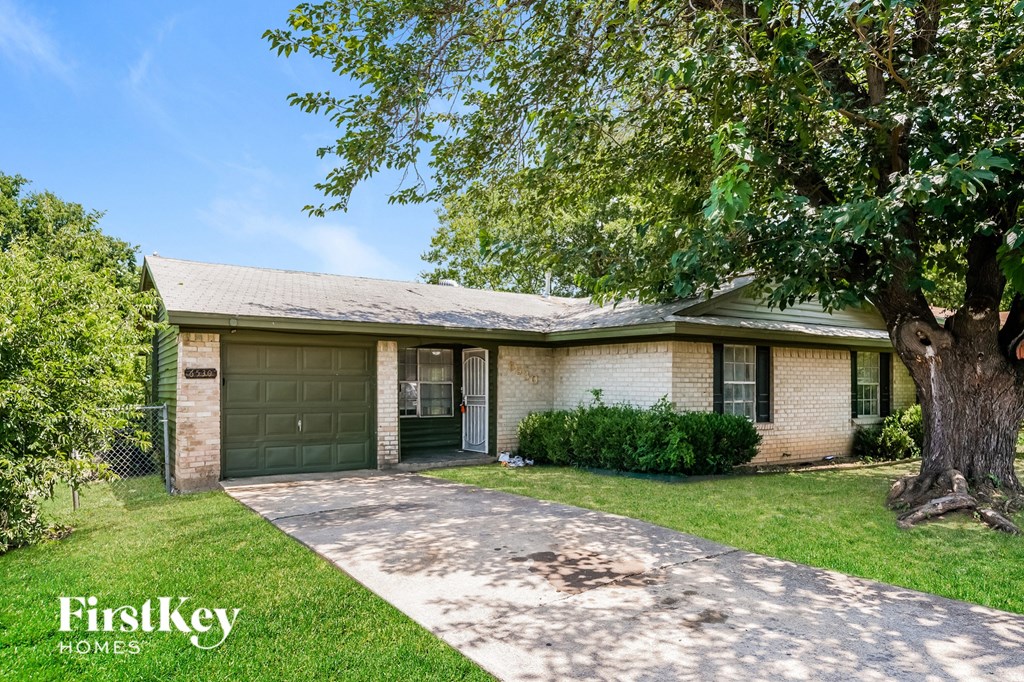 a small brick house with a tree in front of it