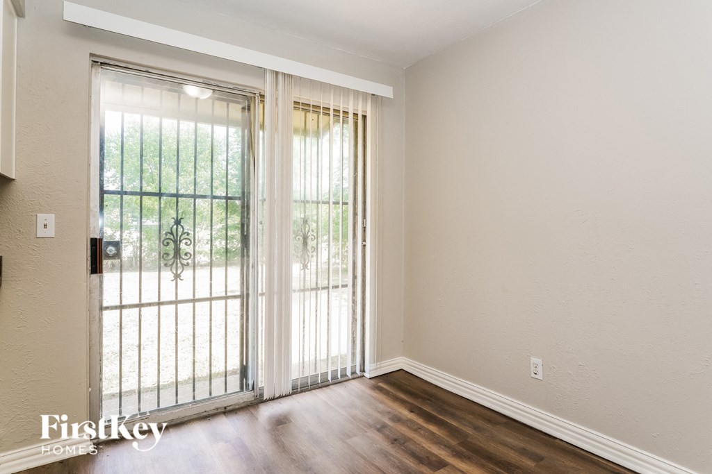 a living room with a sliding glass door and wooden floors