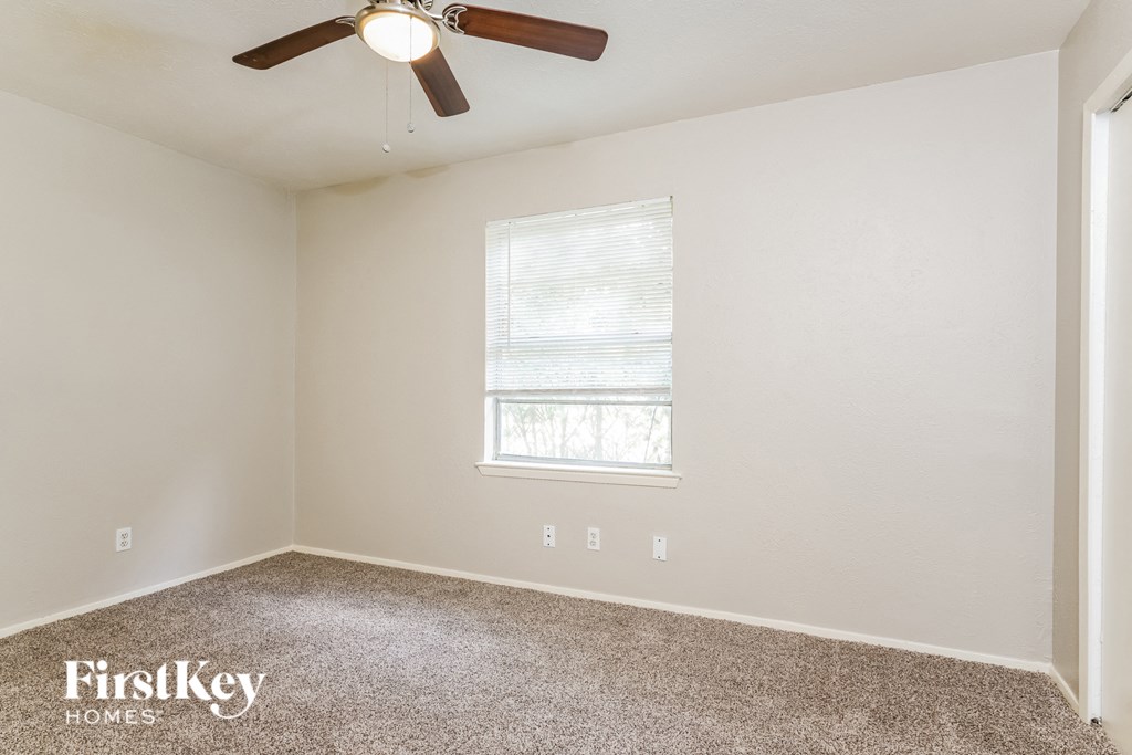 a bedroom with a ceiling fan and a window
