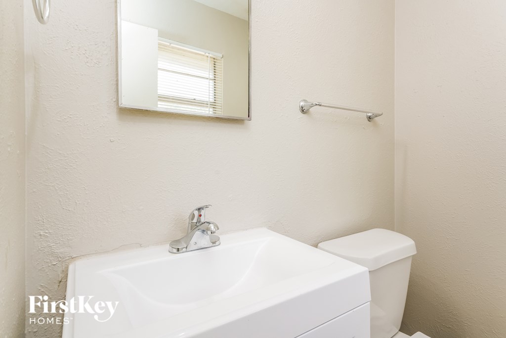 a bathroom with a sink and toilet and a mirror