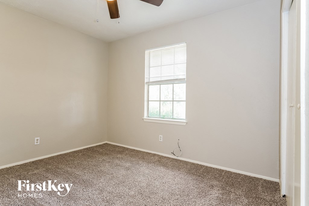 an empty room with carpet and a window