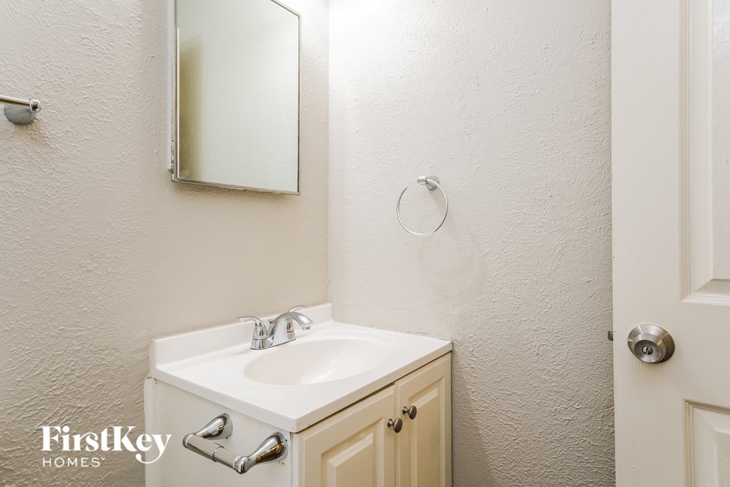 a bathroom with a sink and a mirror and a door