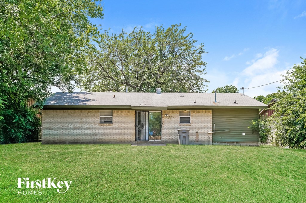 a brick house with a yard and a tree
