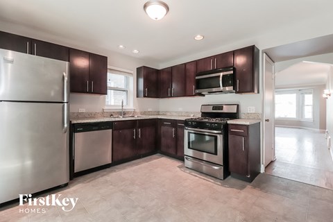 A kitchen with dark brown cabinets and stainless steel appliances.