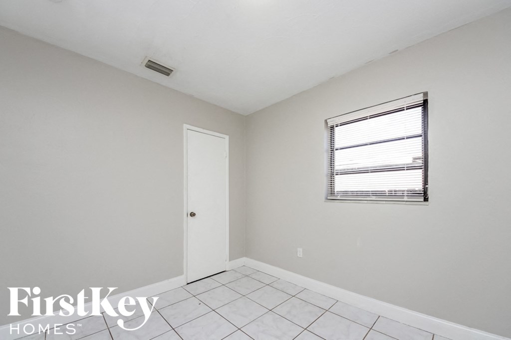 a white room with a window and a white door