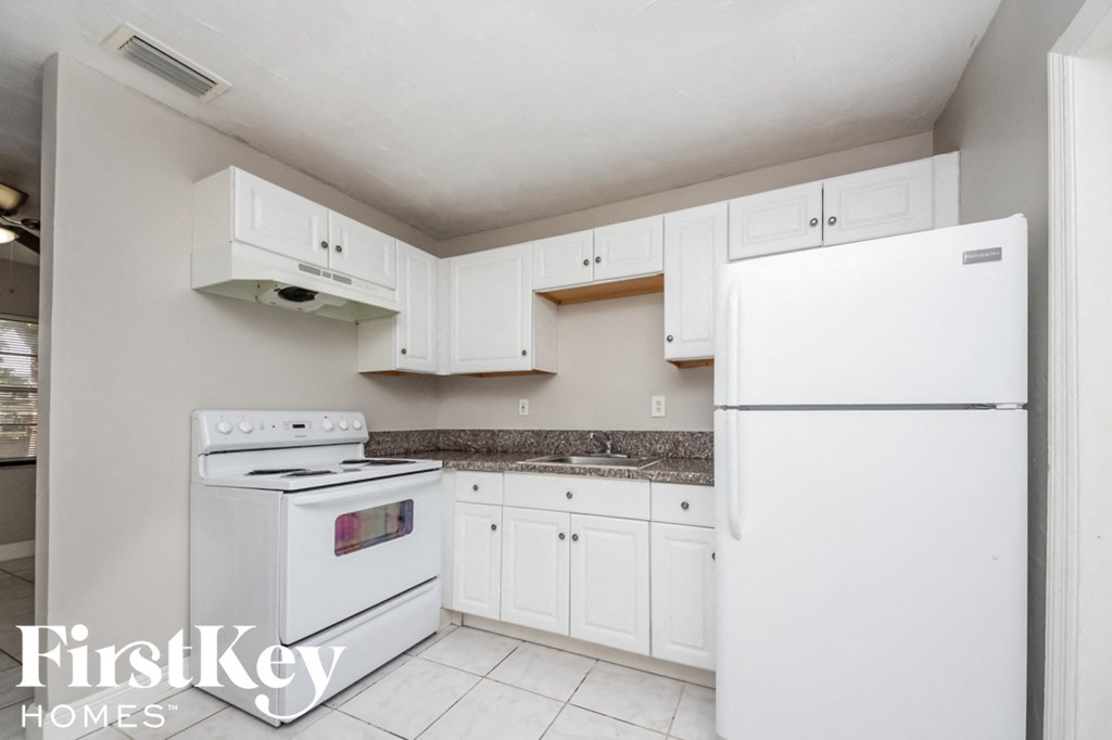 a white kitchen with white appliances and white cabinets