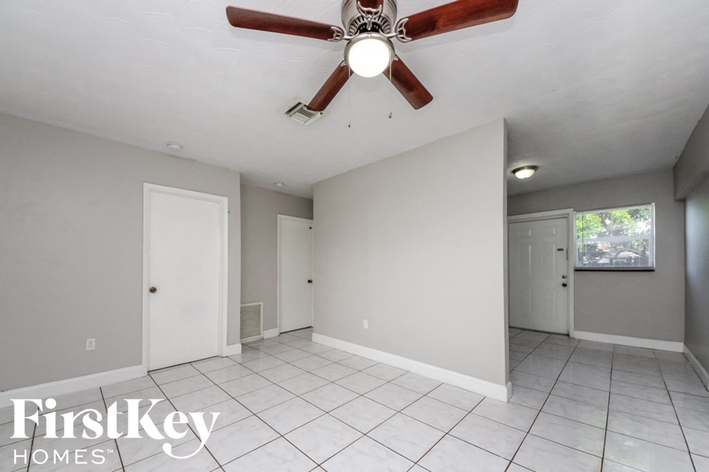 a clean and empty living room with a ceiling fan