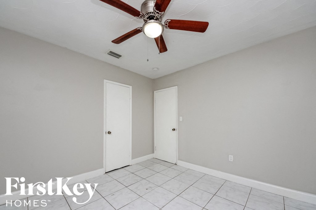 a clean and empty room with a ceiling fan