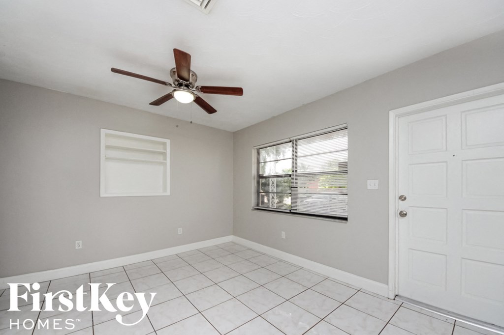 a clean and empty living room with a ceiling fan