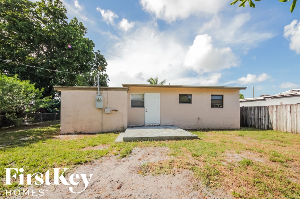 a small house with a yard and a white door
