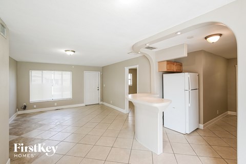 A kitchen area with a refrigerator and a sink.