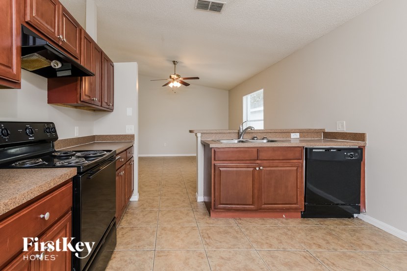 A kitchen with a black stove top oven and a black dishwasher.