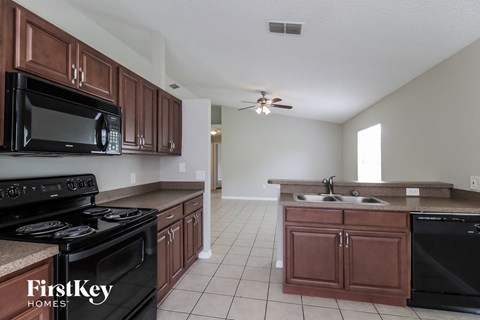 a kitchen with wood cabinets and black appliances and a black stove top oven