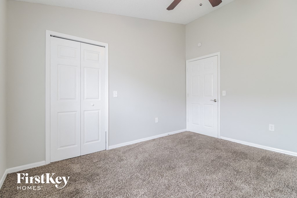 a bedroom with two doors and a carpeted floor