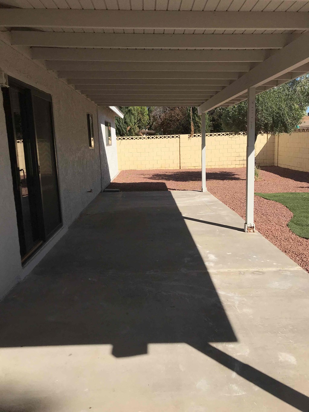 A long concrete walkway leads to a building with a white roof.