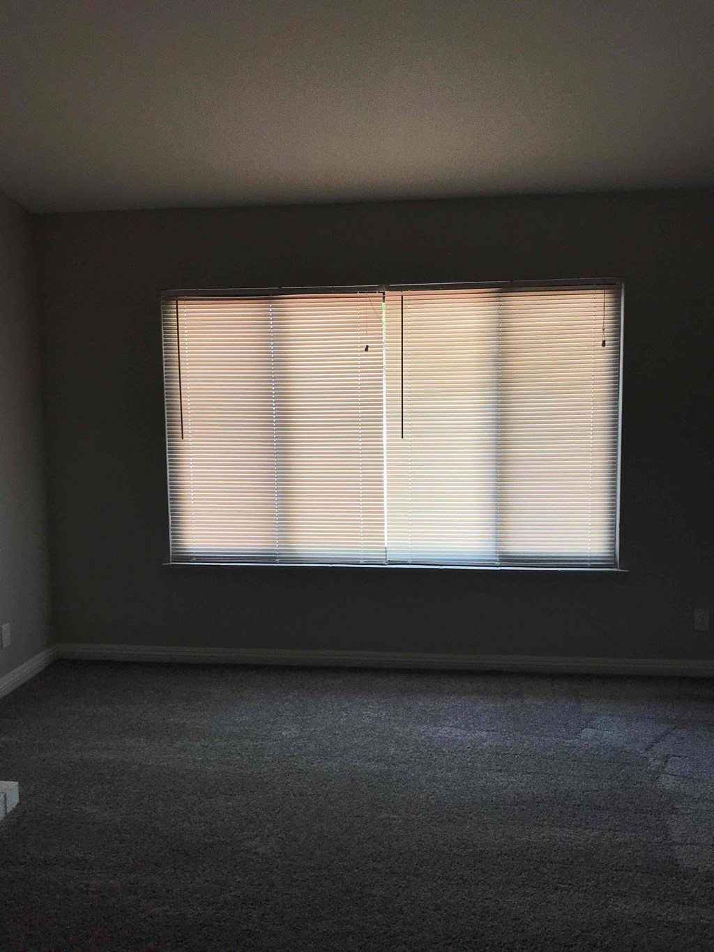 A room with a window covered in blinds.