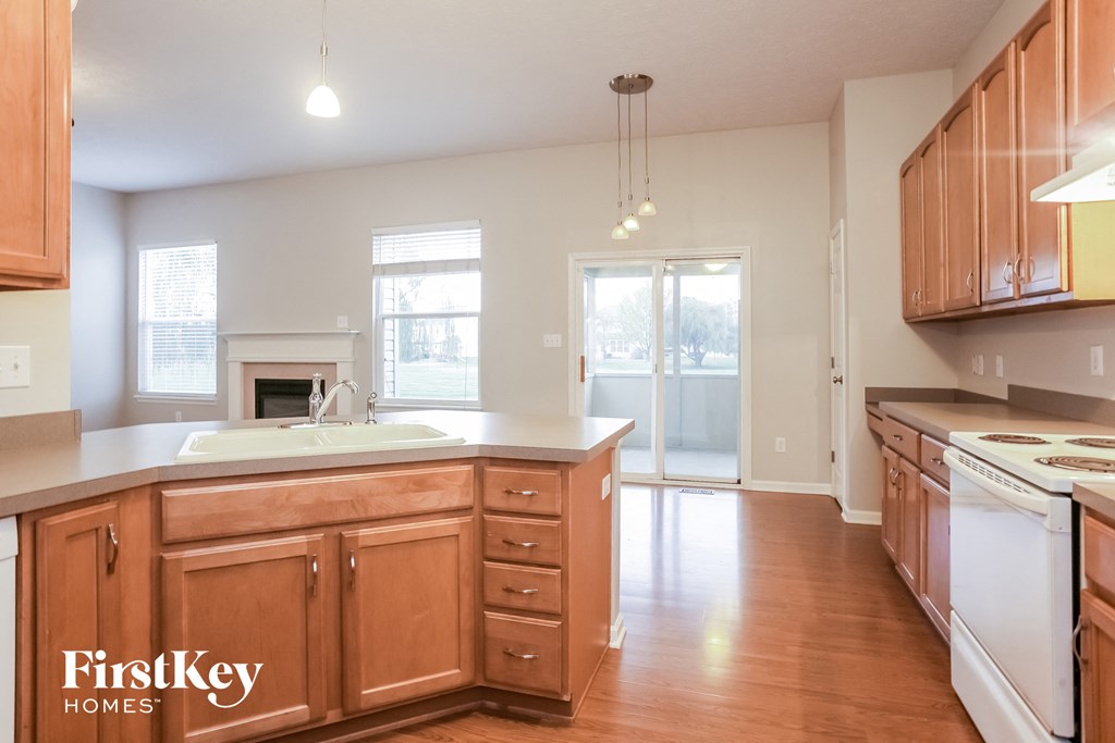 an empty kitchen with wooden cabinets and a white counter top
