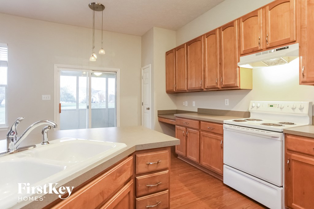 an empty kitchen with wooden cabinets and white appliances