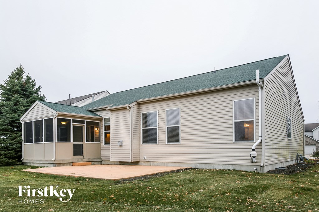 the front of a white house with a green roof