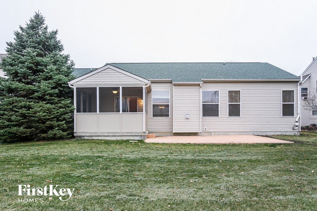 a small white house with a yard and a pine tree